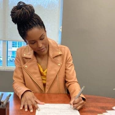 Jasmine Brown signing closing documents on a real estate deal