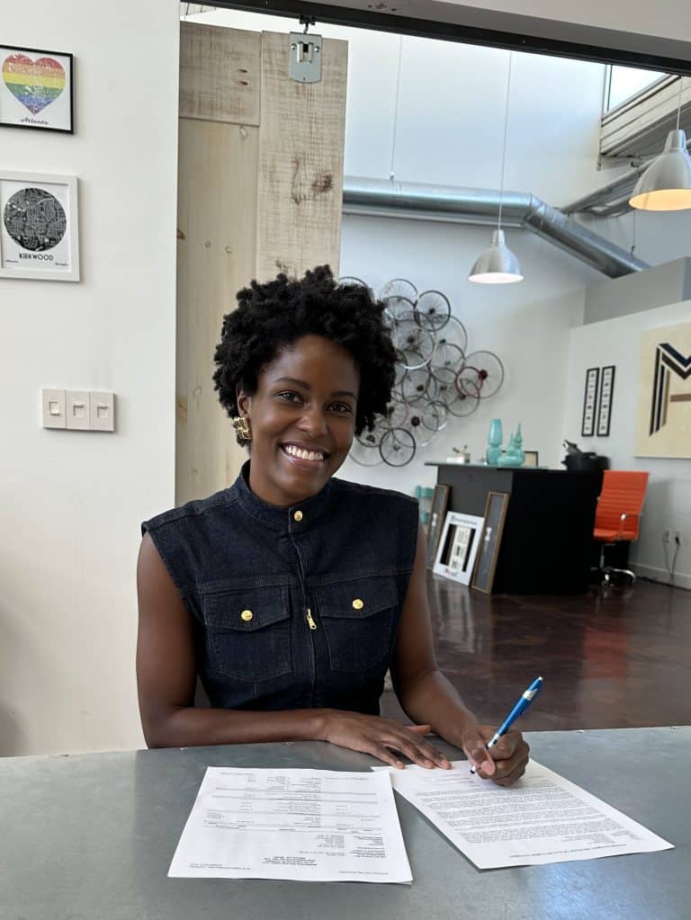 Jasmine Brown smiling while signing closing paperwork